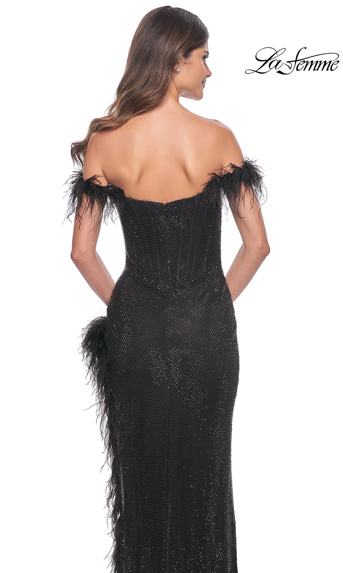 Woman faces away from the camera in the Feather-Trim La Femme Long Black Prom Dress 32151 with an off-the-shoulder design and feather trim, set against a white background. The